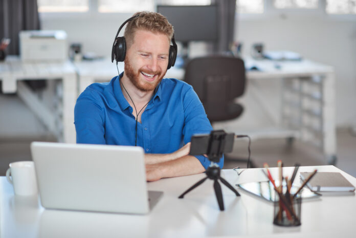 Young Caucasian employee having video call over smart phone whil e-learning